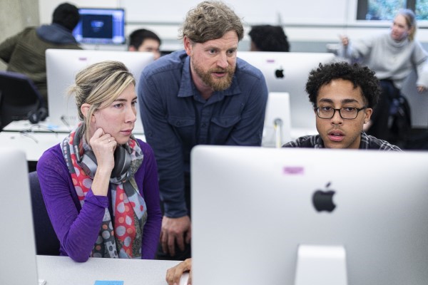 Students and professor looking at a computer