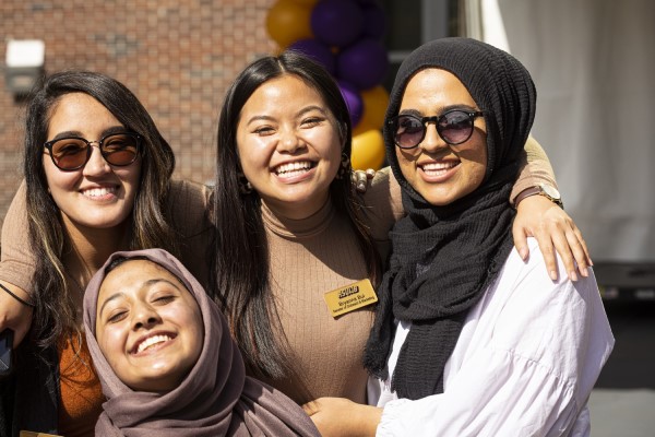 Group of students huddled and posing for a photo