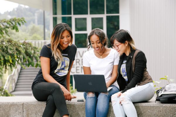 Three students looking at laptop