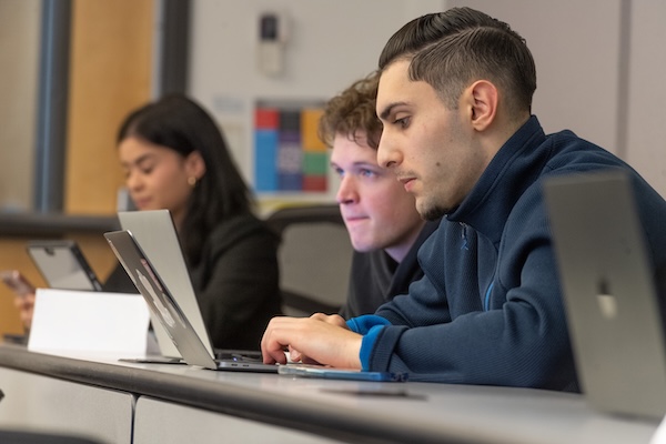 Two people in a classroom with computers.