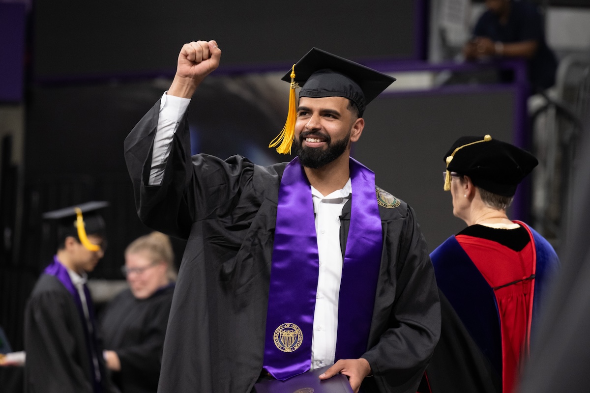 Graduate celebrating commencement in cap and gown.
