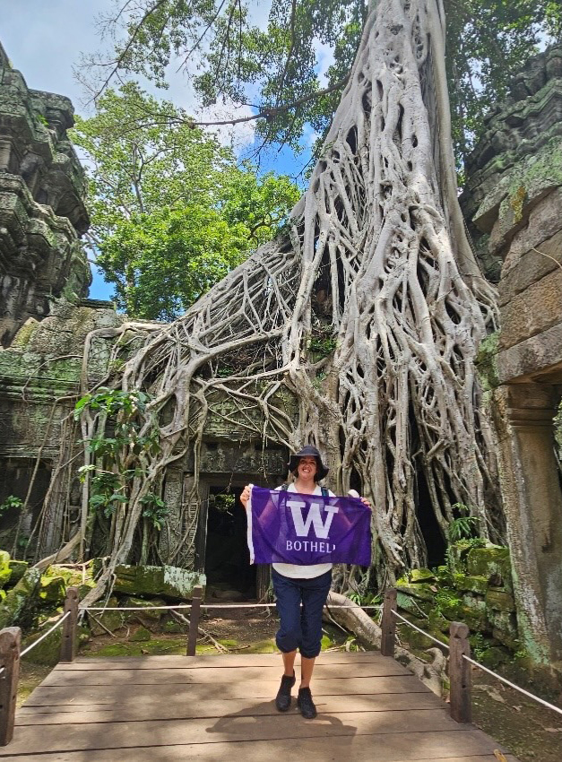 Images shows Alexandra holding up a UW Bothell flag in Cambodia.