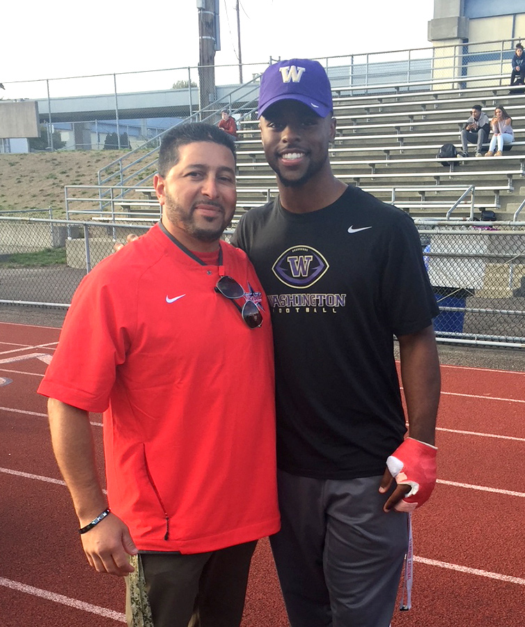 Hector posing with a man wearing Washington Football attire.
