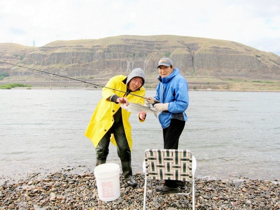 Jason Moon and his father holding up a fish while fishing on the banks of the Columbia River in Eastern Washington.