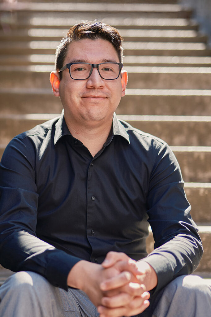 Alfred Albear sitting on an stair in an outdoor stairwell.