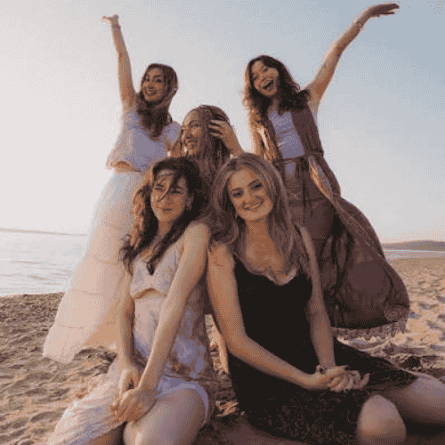 5 members of the musical group Daughters of Venus smiling at the camera