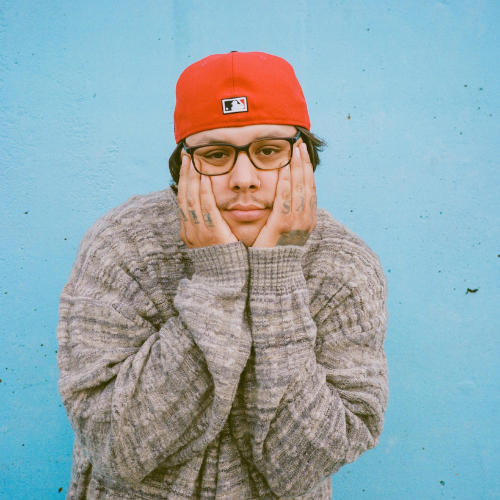 musical artist Travis Thompson looking at camera with hands on his cheeks