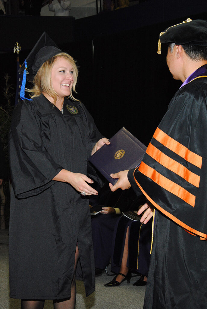 Photo showing Stephanie receiving her diploma at the UW Bothell graduation in 2016.