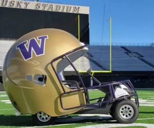 Golf cart transformed into a drivable gold football helmet featuring the University of Washington W on the side.