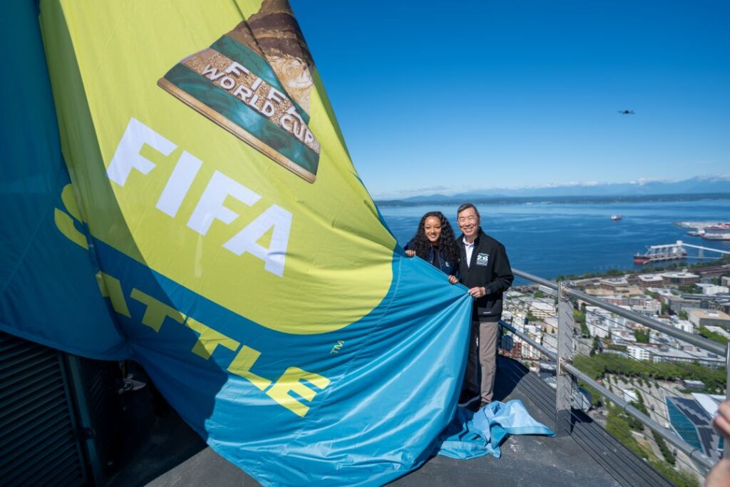 Hana Tadesse unfurling a FIFA World Cup flag on top of the Space Needle