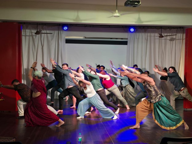 Students and professors dancing on a stage with dancers