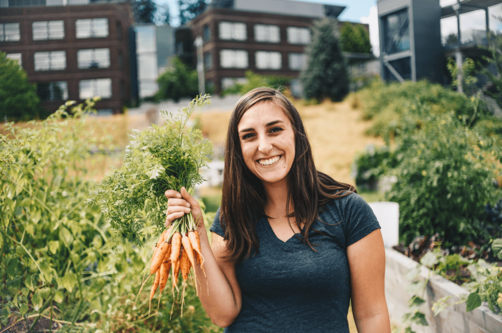 Person holding up carrots from the campus farm.