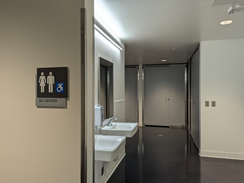 "All gender" sign at the entrance to the all gender restroom in Innovation Hall. The floor-to-ceiling privacy stalls are visible in the back.
