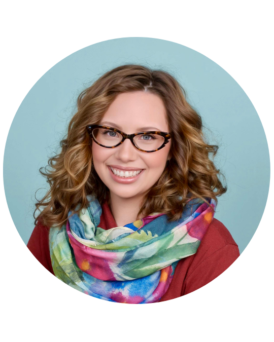 Kelsey Denney wears glasses and a red sweater with a multicolored scarf.