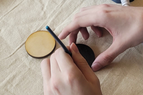 student making a wood circle for a magnet