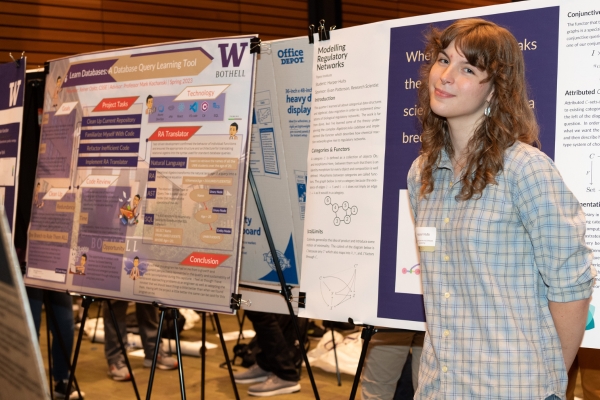 Harper Hults, Research student, stands next to their research poster at symposium