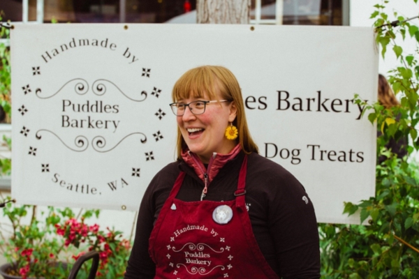 Kari Kalway standing next to the sign of her Puddles Barkery