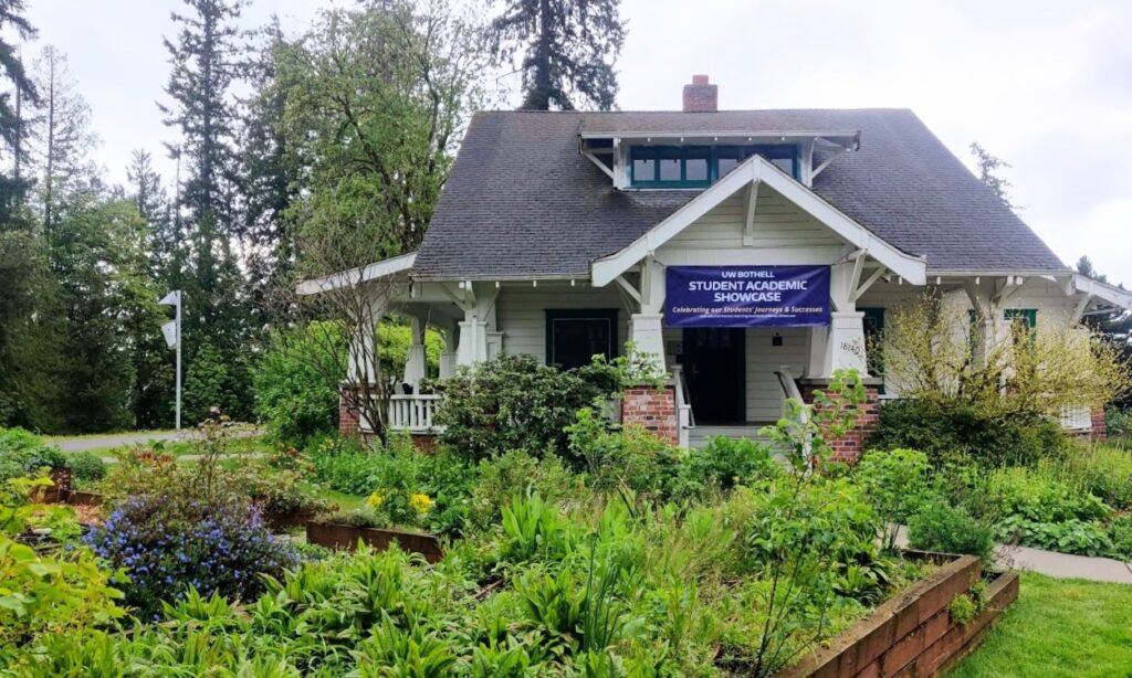 Truly House with green garden in front and purple Showcase banner on porch