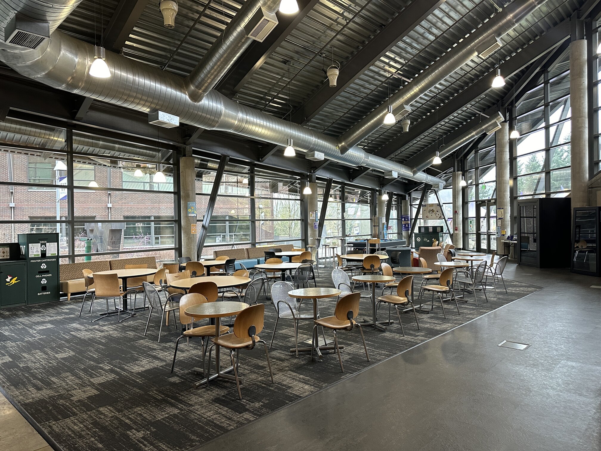 Commons area for socialization. Various sized tables with chairs in a cafe style setting. Located in front of the Gold Brew Cafe in UW2.