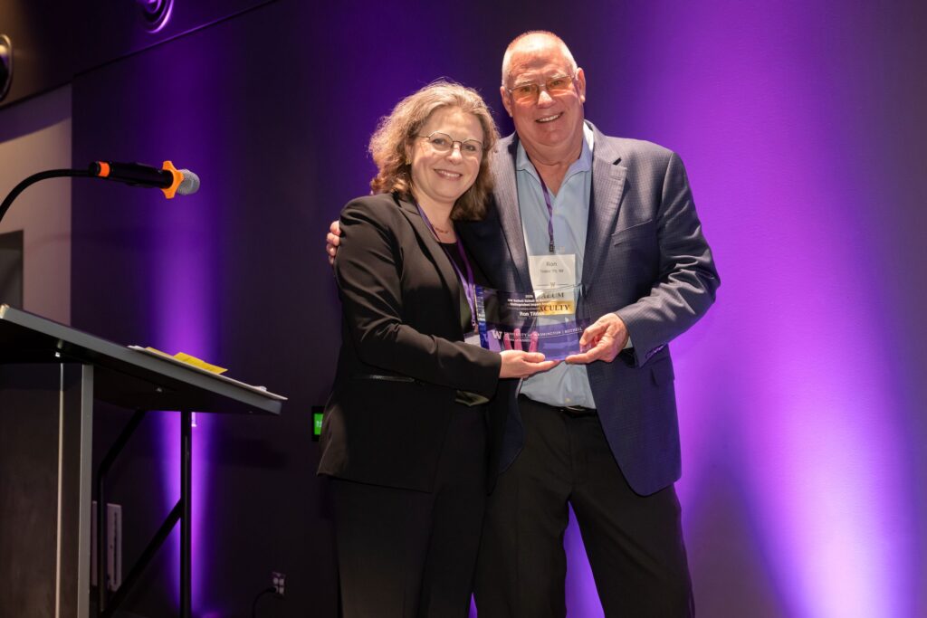 Ron Tilden accepting the Distinguished Impact Award from Dean Sophie Leroy