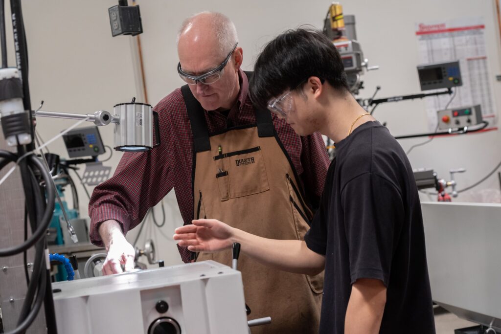 Student learning to use a machine from a professor