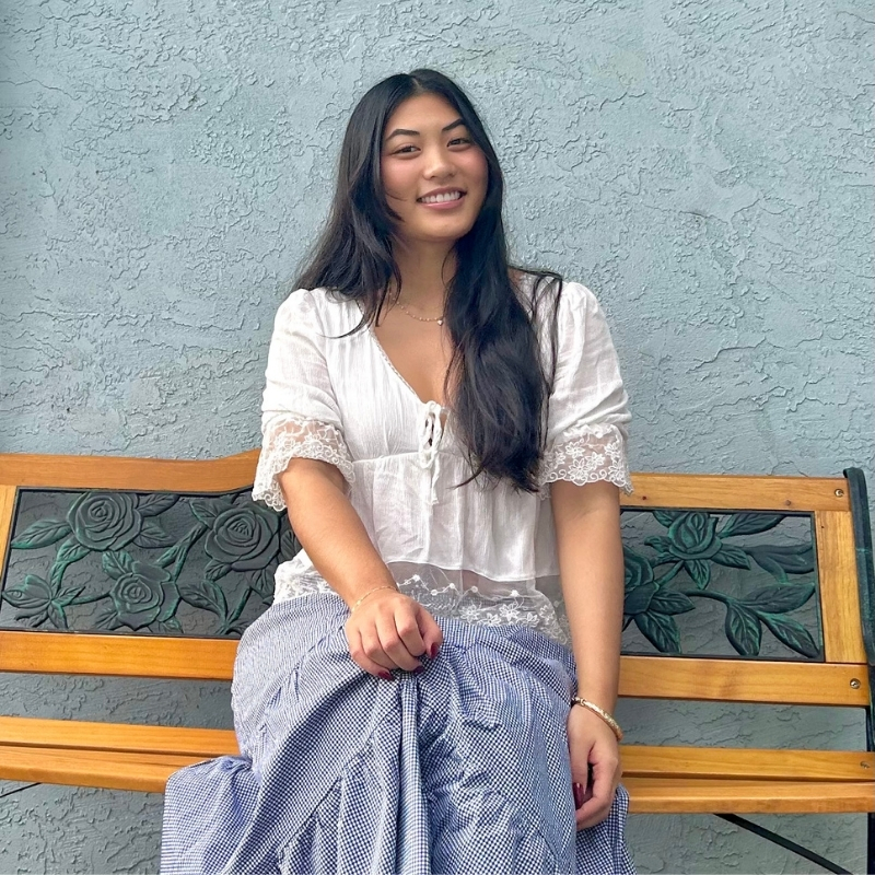 Emilyn sits on a bench