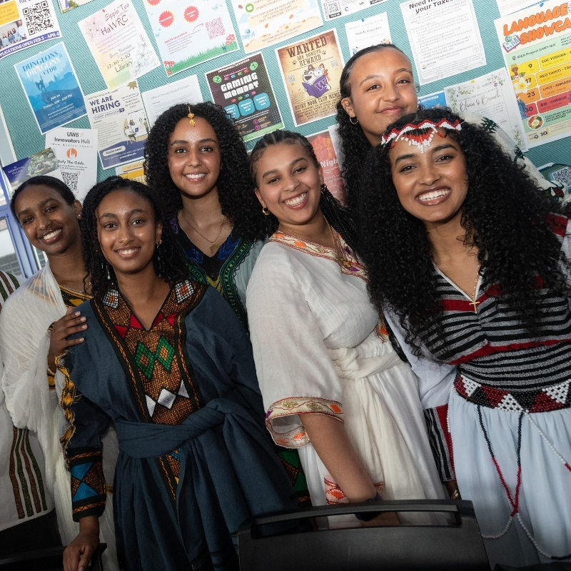 Koket Gebiremichael, right, poses with five members of BunaTalk wearing traditional East African clothing.