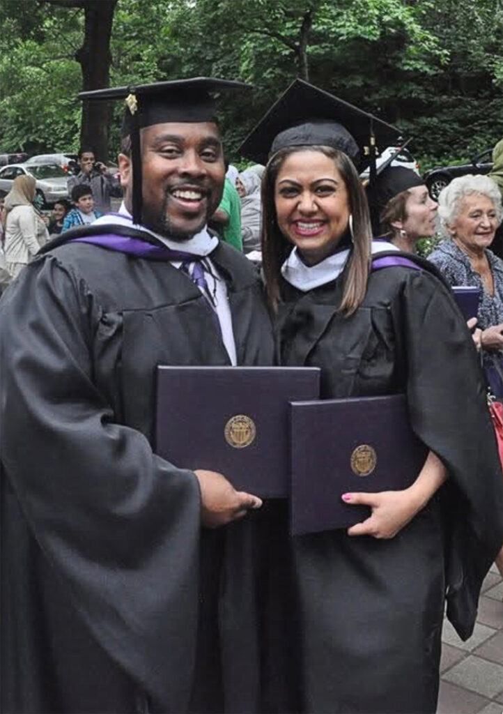 Paul Johnson and Priya Frank smile in caps and gowns while holding their diploma covers at UW Bothell’s 2011 commencement ceremony.
