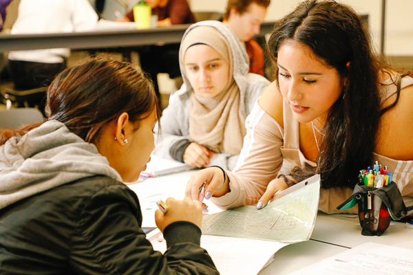 three students discussing an assignment