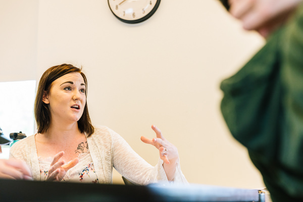 Student speaking in a classroom and moving their hands.