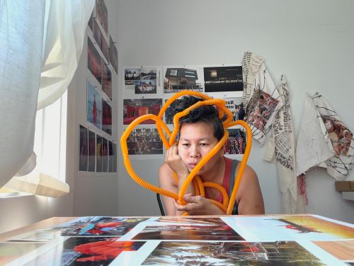 Anida Yoeu Ali thinking deeply in studio space at Interlude Artist Residency.