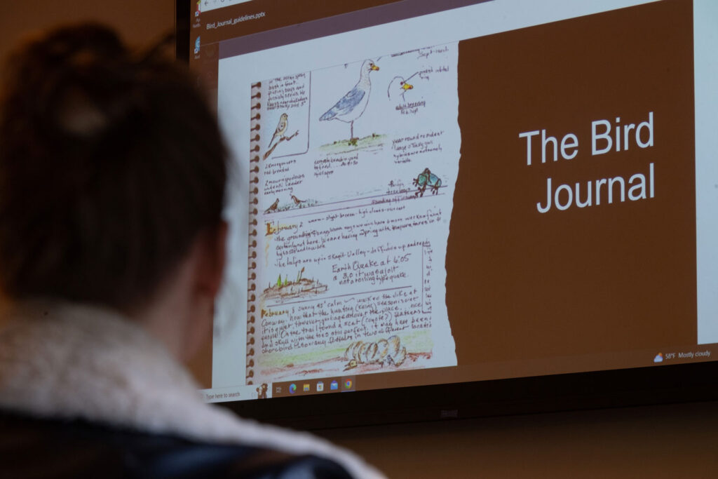 A projector screen that says "The Bird Journal."