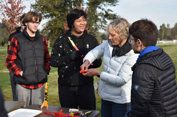 A group of people holding model rockets.