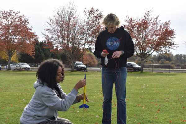 Two people with a model rocket.