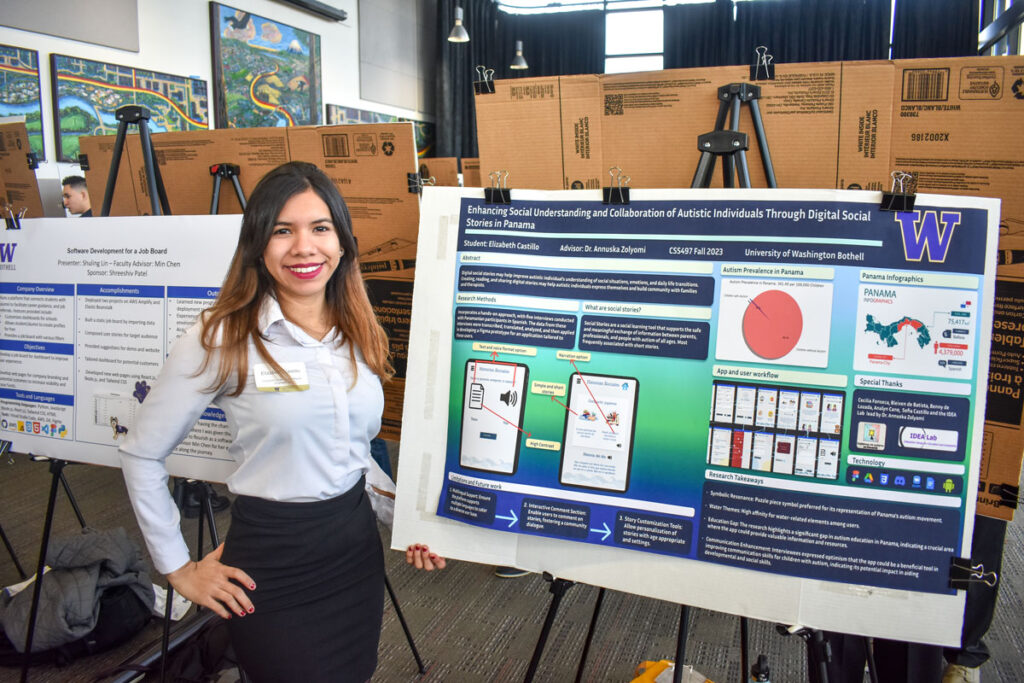 A person standing next to a poster.