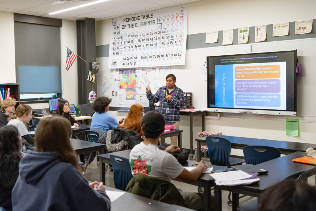 A person in front of a classroom of students.