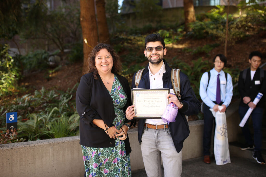 Two people pose for a photo with an award.