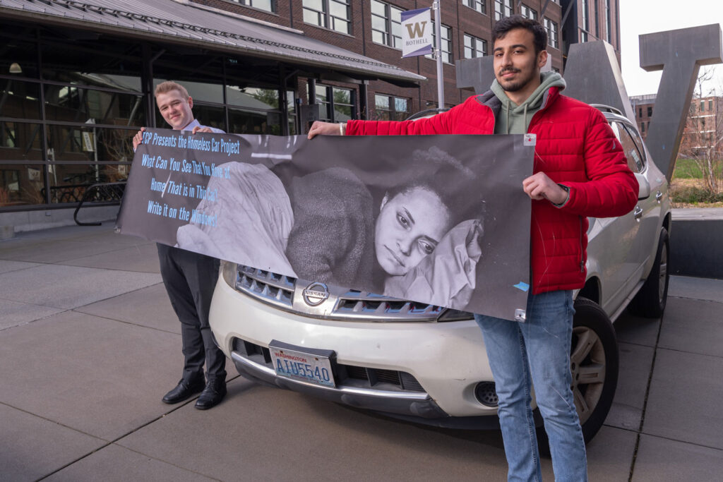 Two people hold up a sign.