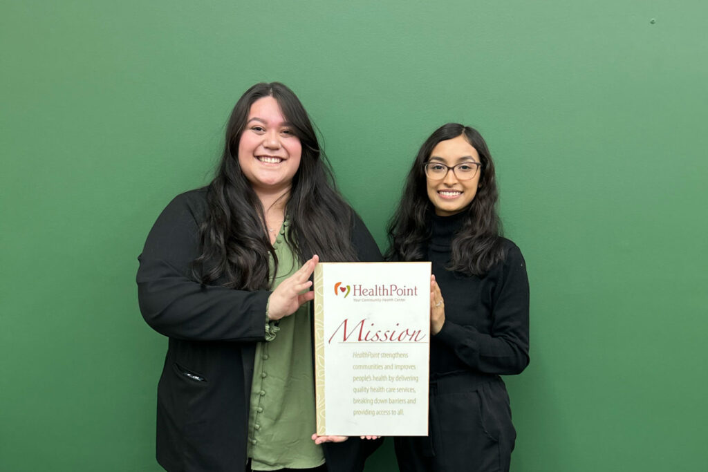 Two people holding up a mission statement.