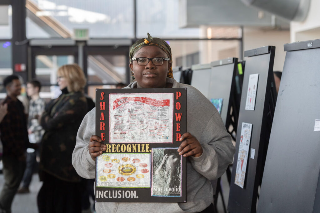 A person holding a piece of art.