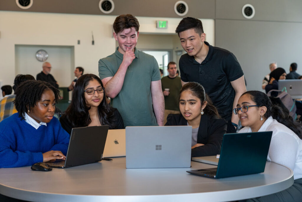 A group of people look at computers.