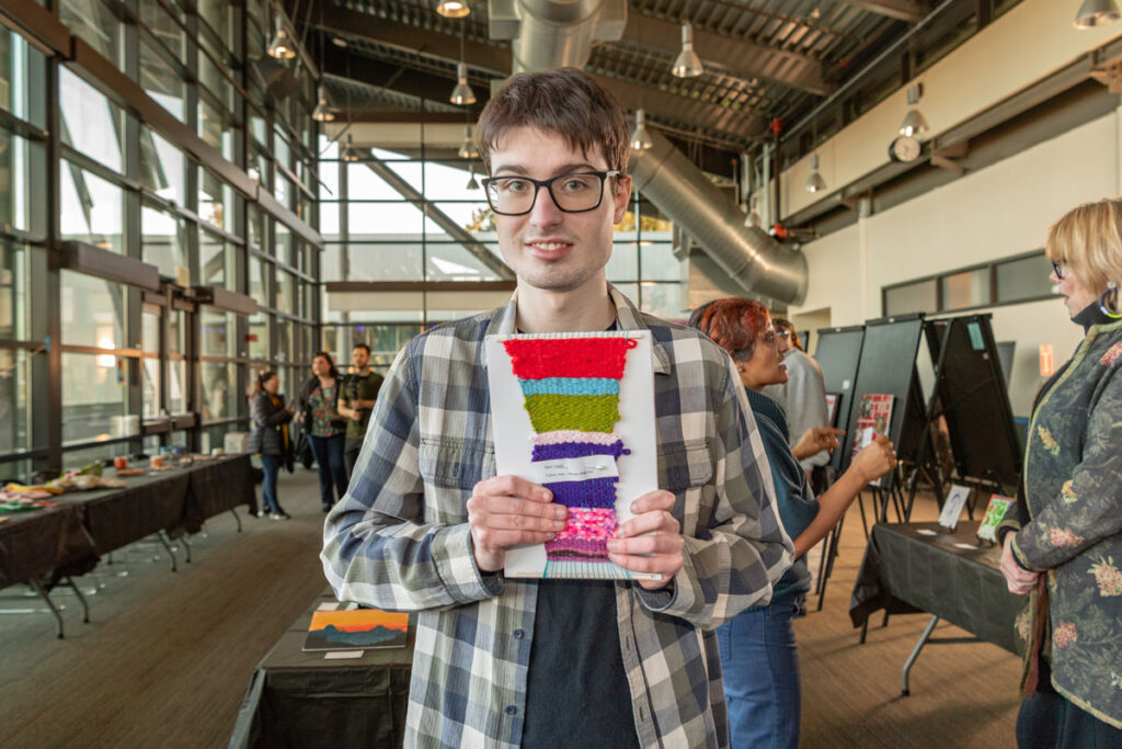A person holding a piece of art.