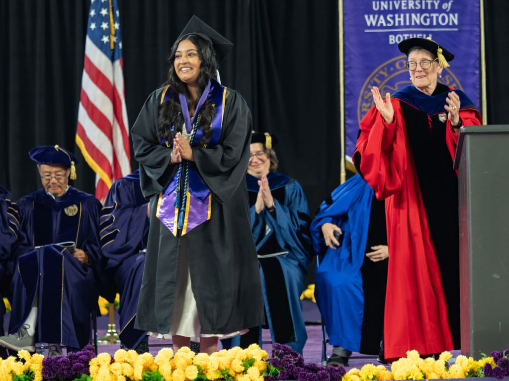 People on a stage in caps and gowns.