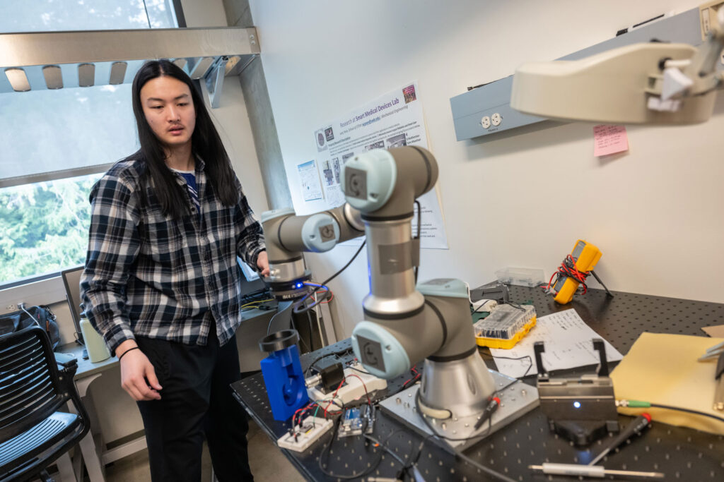 A person next to a robot arm.