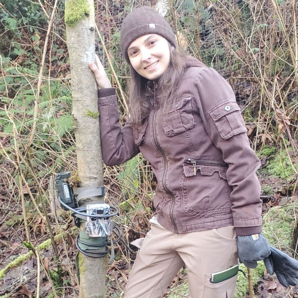 A person next to a tree with a device on it.