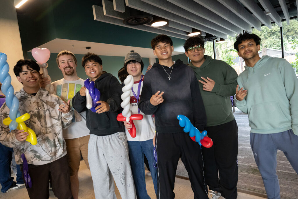 A group of people holding balloon swords.