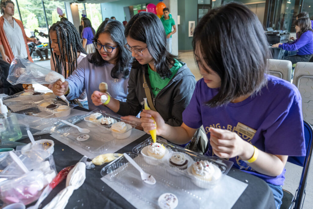 A group of people decorating cupcakes.