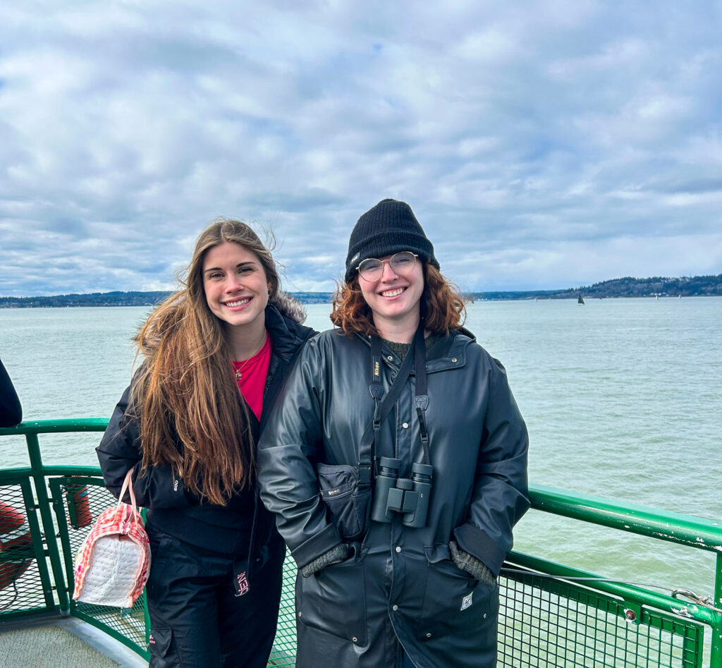 Two people on a ferry with water in the background.