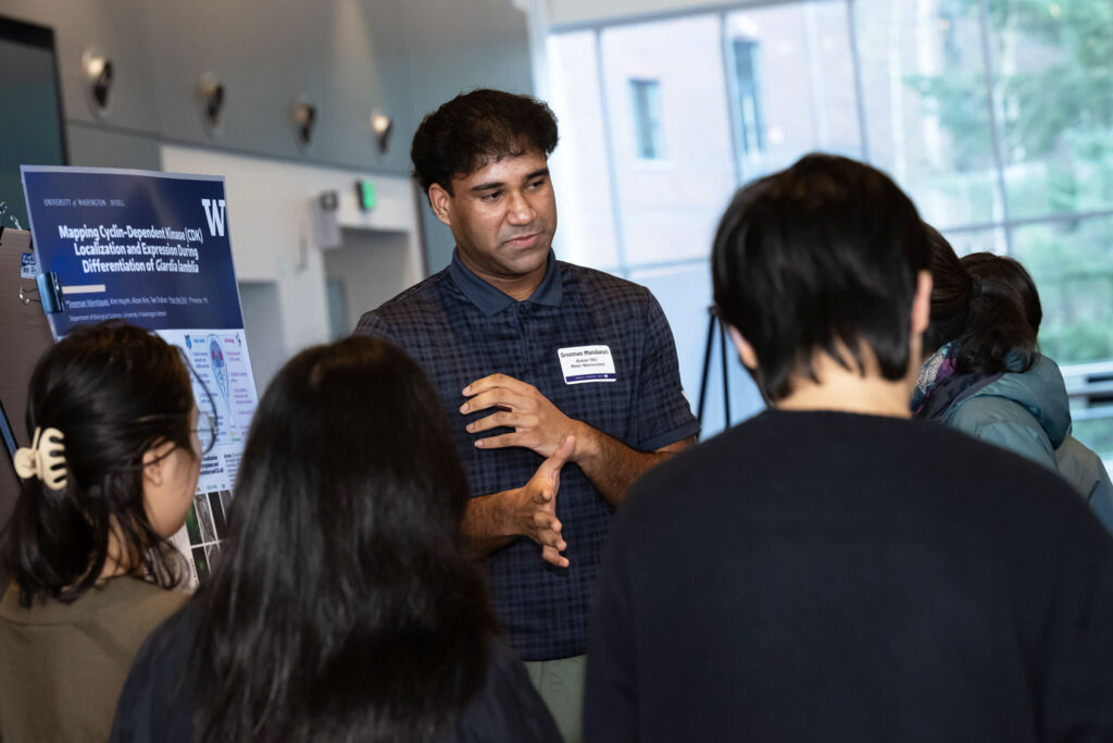 A group of people talking near a poster.