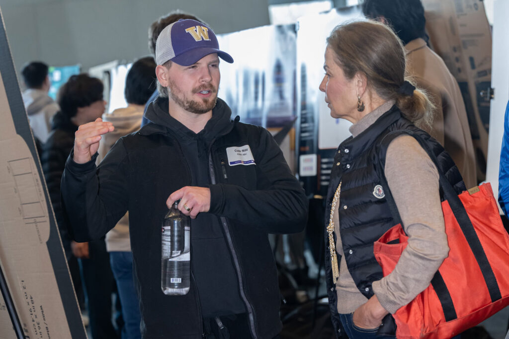 People talking in front of a poster.